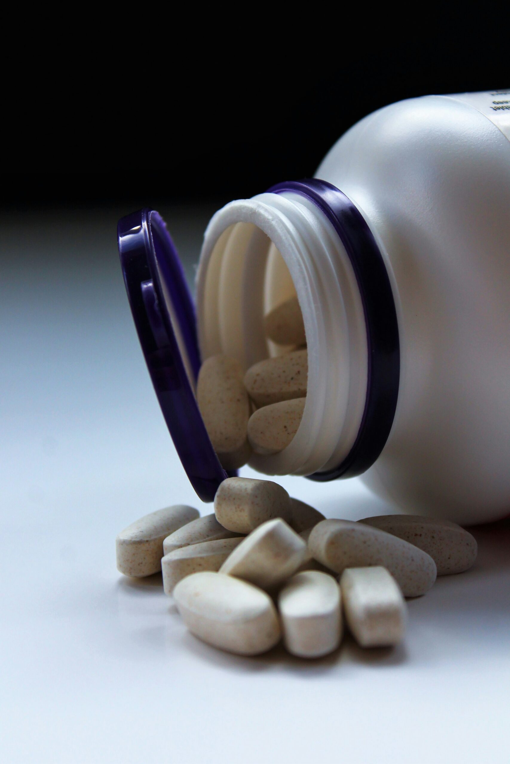 Ovale Tabletten fallen aus einer PET-Dose