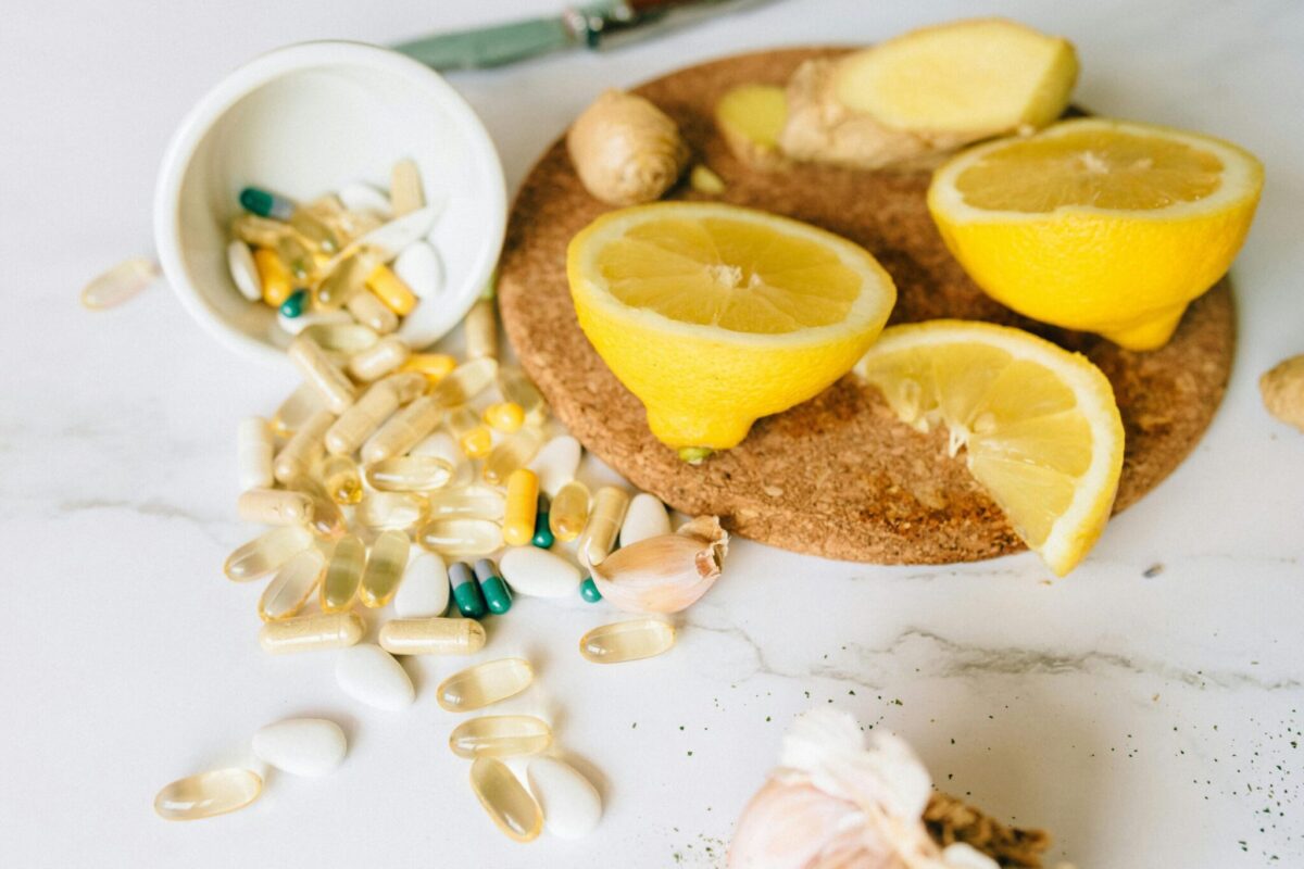 Verschiedene Kapseln mit Zitrone und Ingwer – Symbol für Vitamine und Mineralstoffe